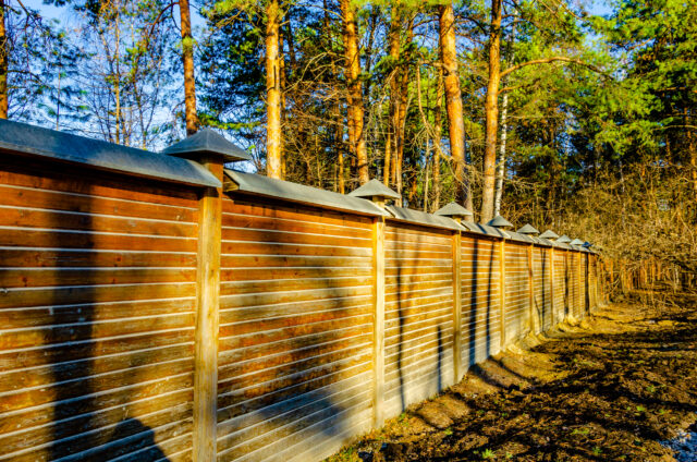https://guardianfencing.us/wp-content/uploads/2025/02/wooden-fence-with-metal-roof-that-says-s-it-1-640x424.jpg